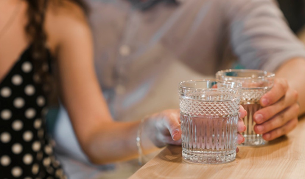 Clienti (senza distanziamento) consumano bevande al bar: locale chiuso