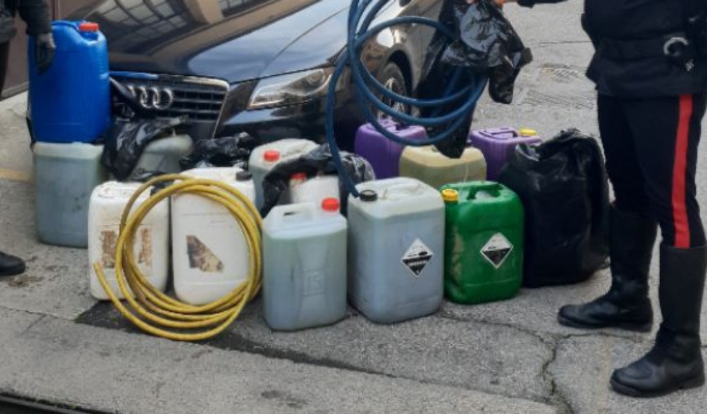 Con un tubo di gomma “spilla” alcune decine di litri di gasolio da un escavatore