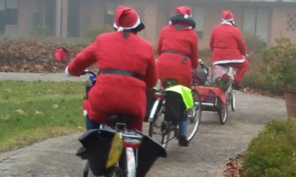 Babbo Natale arriva in bicicletta per fare gli auguri ai bambini