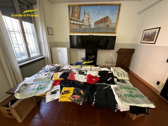 Abbigliamento “tarocco” in vendita sui banconi del mercato di piazza Stradivari