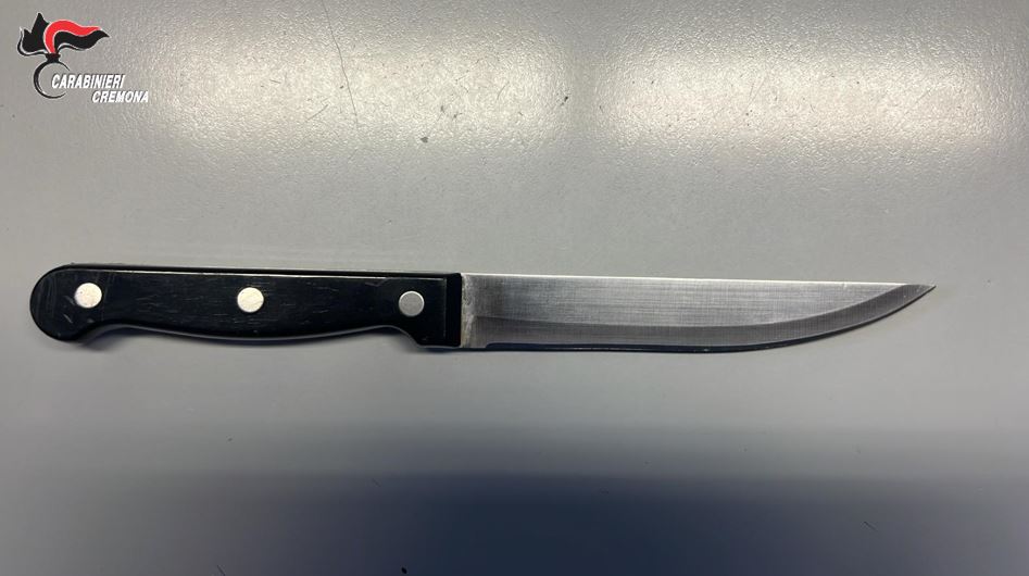Lancia bottiglie a terra e minaccia i passanti con un coltello da cucina